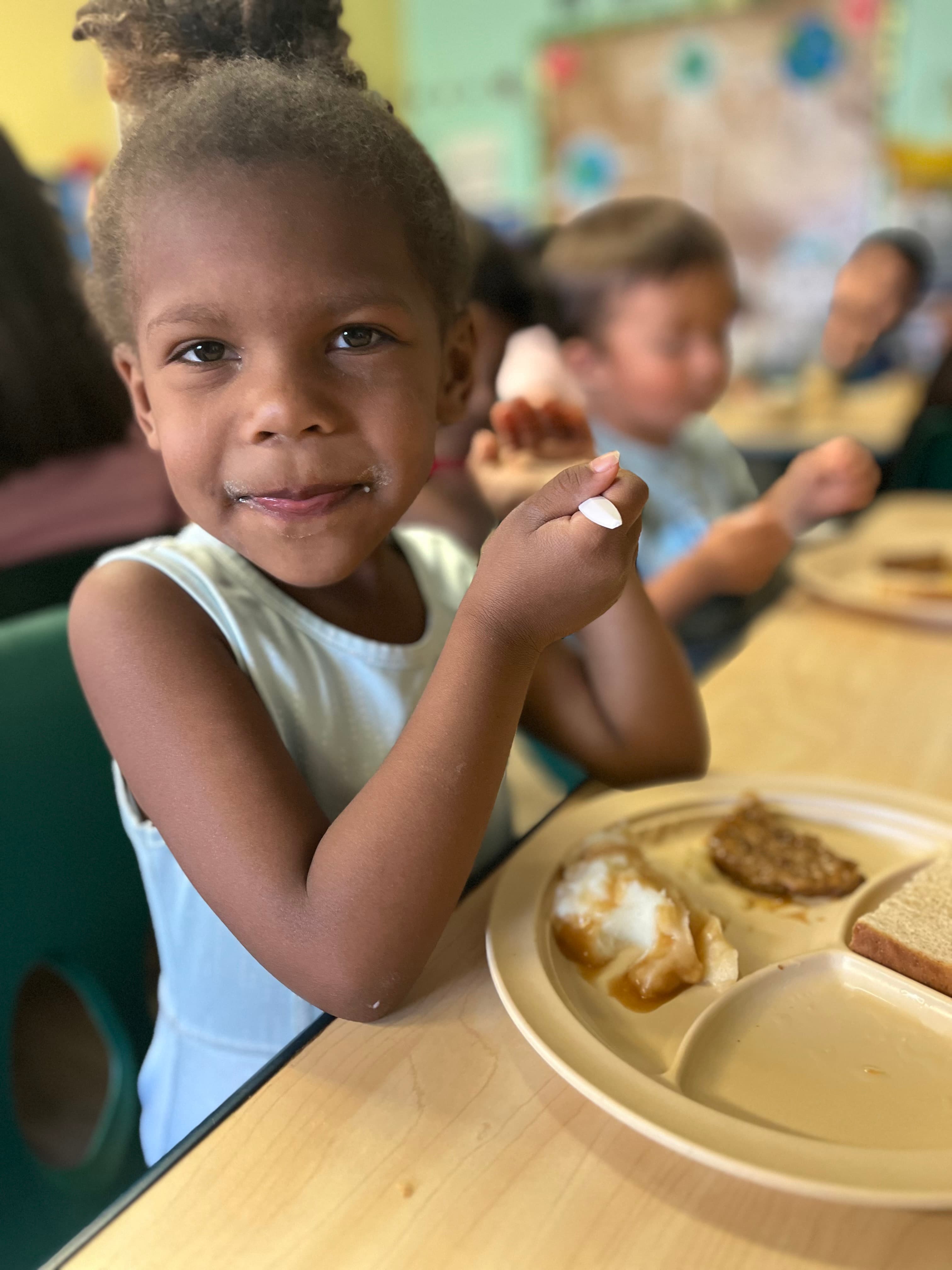 Girl enjoying a fresh meal prepared on-site at ABQ Childcare